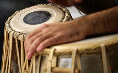 Indian classical musicians performing fusion music with traditional instruments and modern sounds on stage.