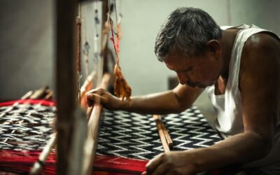Artisan weaving handloom fabric showcasing sustainable fashion trends in 2025.